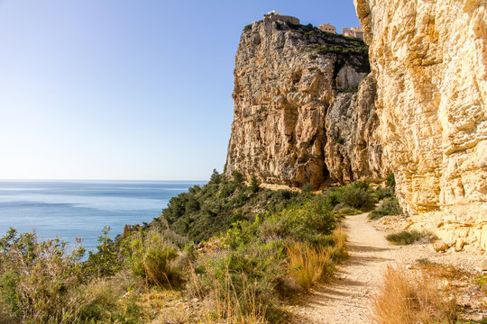 A path through a cliff at Moraig cove beach in Benitatxell, Alicante, Spain