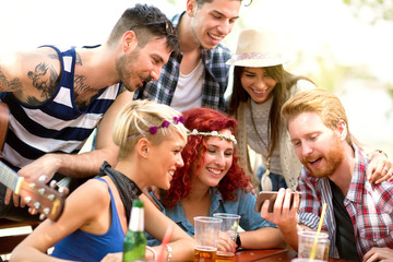 Young people having fun while watching something interesting on mobile phone his friends