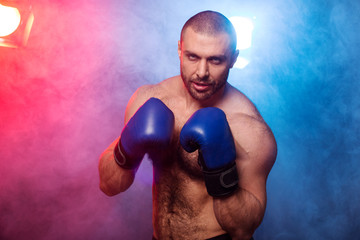 Young muscular kickboxing fighter practicing kicks. Kick boxer doing an exercise for the fight....