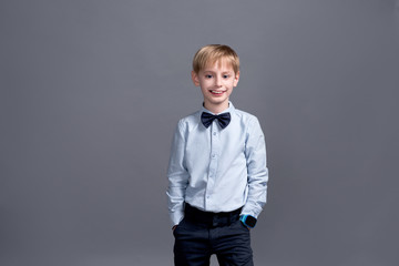 little boy posing on grey background