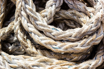 Frayed boat rope. Massive nautical dirty shabby white ropes background texture close up. Detail of old used coiled jute ship seaman's rope. Fishing or boat accessories. Image.