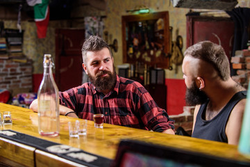 Men relaxing at bar. Strong alcohol drinks. Friday relaxation in bar. Friends relaxing in bar or pub. Interesting conversation. Hipster brutal bearded man spend leisure with friend at bar counter
