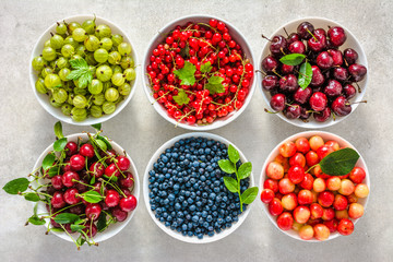 Bowls with fruit. Fresh assortment of fruits, variety of berry in a bowls. Cherry, red strawberry, blueberry and currant.