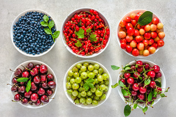 Bowls with berry. Fresh assortment of berries, variety of fruits in a bowls. Cherry, red strawberry, blueberry and currant.