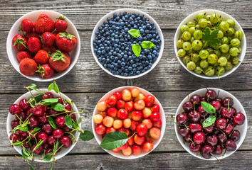 Bowls with fruit. Fresh assortment of fruits, variety of berry in a bowls. Cherry, red strawberry, blueberry and currant.
