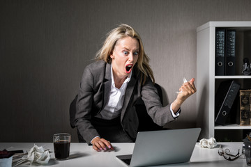 Woman angry at her laptop computer at work