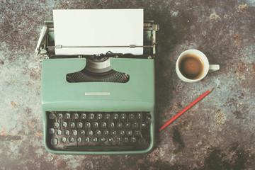 old typewriter next to a cup of coffee