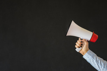 Person holding megaphone on empty black background