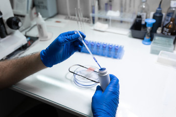 scientist prepare blood sample for research on microscope. Placing blood sample on microscope slide