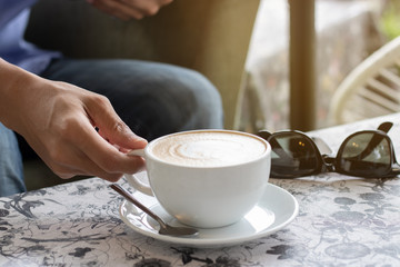 Human hand are holding a cup of coffee