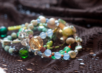 selective focus of multicolored bracelets on brown lace on white 