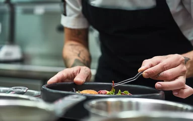 Gordijnen Creative Cooking. Cropped image of chef hands garnishing Pasta carbonara in a restaurant kitchen. © Friends Stock