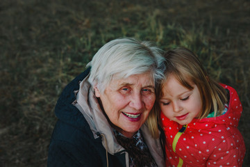 happy grandmother and granddaughter hug in nature