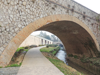 Ancient arch over the pedestrian path outside the city walls of Umbertide, Umbria, Italy.