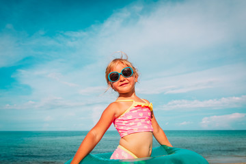 cute happy little girl with toy floating ring at beach