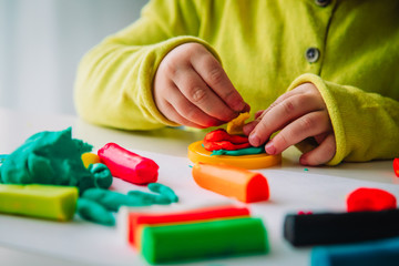 Fototapeta premium Child playing with clay molding shapes, kids crafts