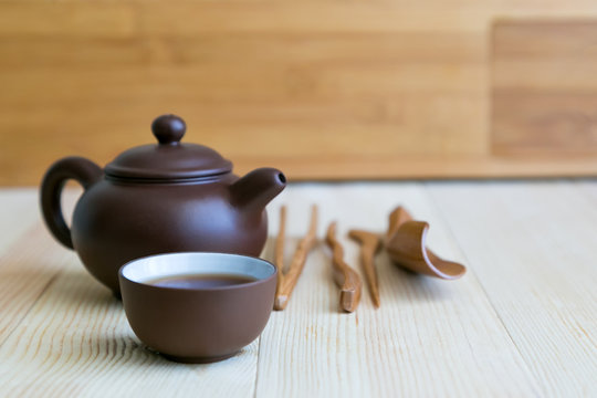 A set accessories for the tea ceremony. Dishes for tea and wooden sticks on a light background.