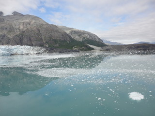Glacier in the midst of gray mountains with little vegetation in Alaska