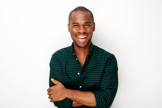 happy young black guy smiling with arms crossed against isolated white background
