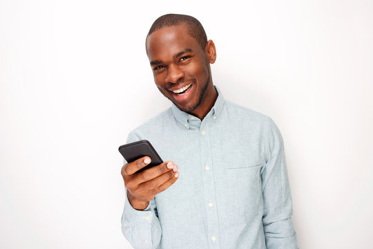 handsome young black man holding mobile phone against white background