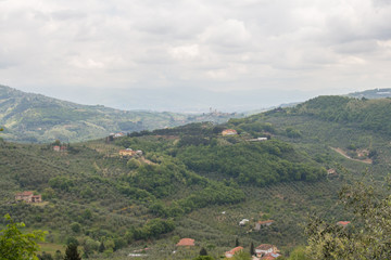 Typical Tuscany landscape with hills, green trees and houses, Italy.