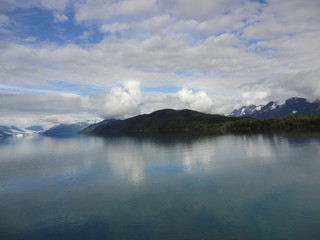 Passage in the Pacific Ocean between two mountain ranges. Calm peaceful waters flowing slowly under a cloudy sky.