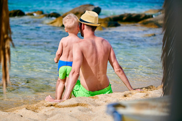 Fototapeta na wymiar Toddler boy on beach with father
