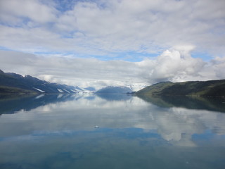 Pacific Ocean calm waters with reflection of the sky and mountains