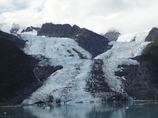 Glaciers within Glacier Bay National Park in Alaska. Glaciers coming over mountain peaks and sliding into the Pacific Ocean