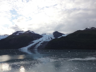 Glaciers within Glacier Bay National Park in Alaska. Glaciers coming over mountain peaks and sliding into the Pacific Ocean