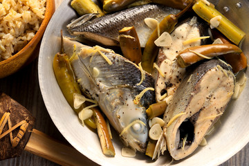Fish stew on white plate with rice. Paksiw na Bangus. Filipino cuisine