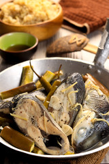 Fish stew on white plate with rice. Paksiw na Bangus. Filipino cuisine