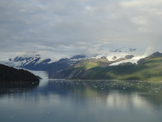 Oceanside Mountains with Glaciers sliding into the Pacific Ocean. Snow capped peaks under a heavily...
