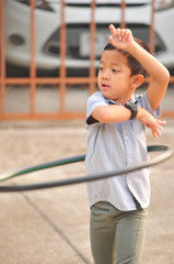 Obraz premium Boy and girl playing hula hoop on the street in town