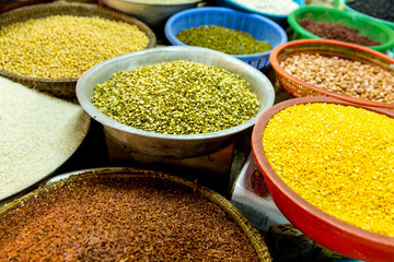 Various grains in large bowls on the market