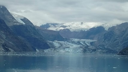 Glaciers within Glacier Bay National Park in Alaska. Glaciers coming over mountain peaks and sliding into the Pacific Ocean