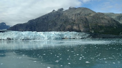 Glaciers within Glacier Bay National Park in Alaska. Glaciers coming over mountain peaks and sliding into the Pacific Ocean