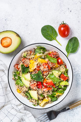 Quinoa salad with fresh vegetables on white.