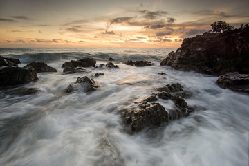 Fototapeta na wymiar Beautiful natural seascape wave hit the rock during sunset