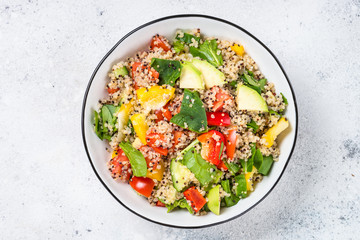 Quinoa salad with fresh vegetables on white.