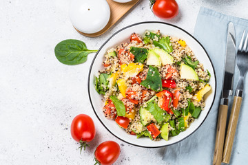 Quinoa salad with fresh vegetables on white.