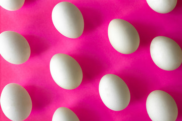 white chicken eggs on a bright pink color background