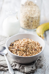 Healthy breakfast bowl. Granola with chocolate and banana on white wooden table. The concept of healthy nutrition and diet.