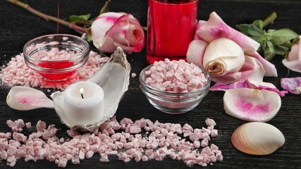 Fototapeta na wymiar Spa and aromatherapy accessories based on rose flowers, black background