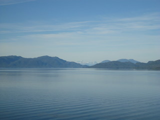 Passage in the Pacific Ocean between two mountain ranges. Calm peaceful waters flowing slowly under a cloudy sky.
