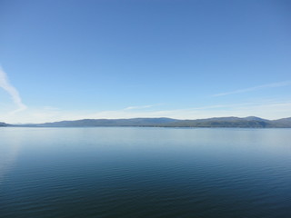 Passage in the Pacific Ocean between two mountain ranges. Calm peaceful waters flowing slowly under a cloudy sky.