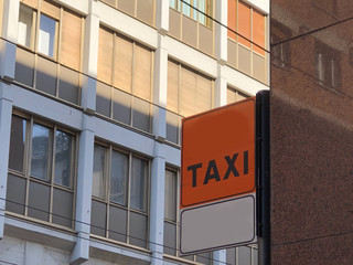 Taxi sign in the city across the buildings