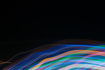 Abstract blurred light lines on black background. Light trails against dark background.