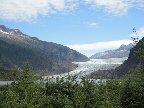 Mendenhall Glacier Juneau Alaska. Mendenhall Glacier flowing into Mendenhall Lake in between mountains with Nugget falls. Perfect tourist location