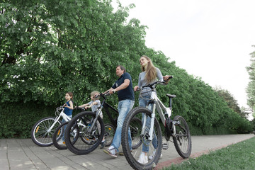 Obraz premium happy family walking with bicycles in the city Park.